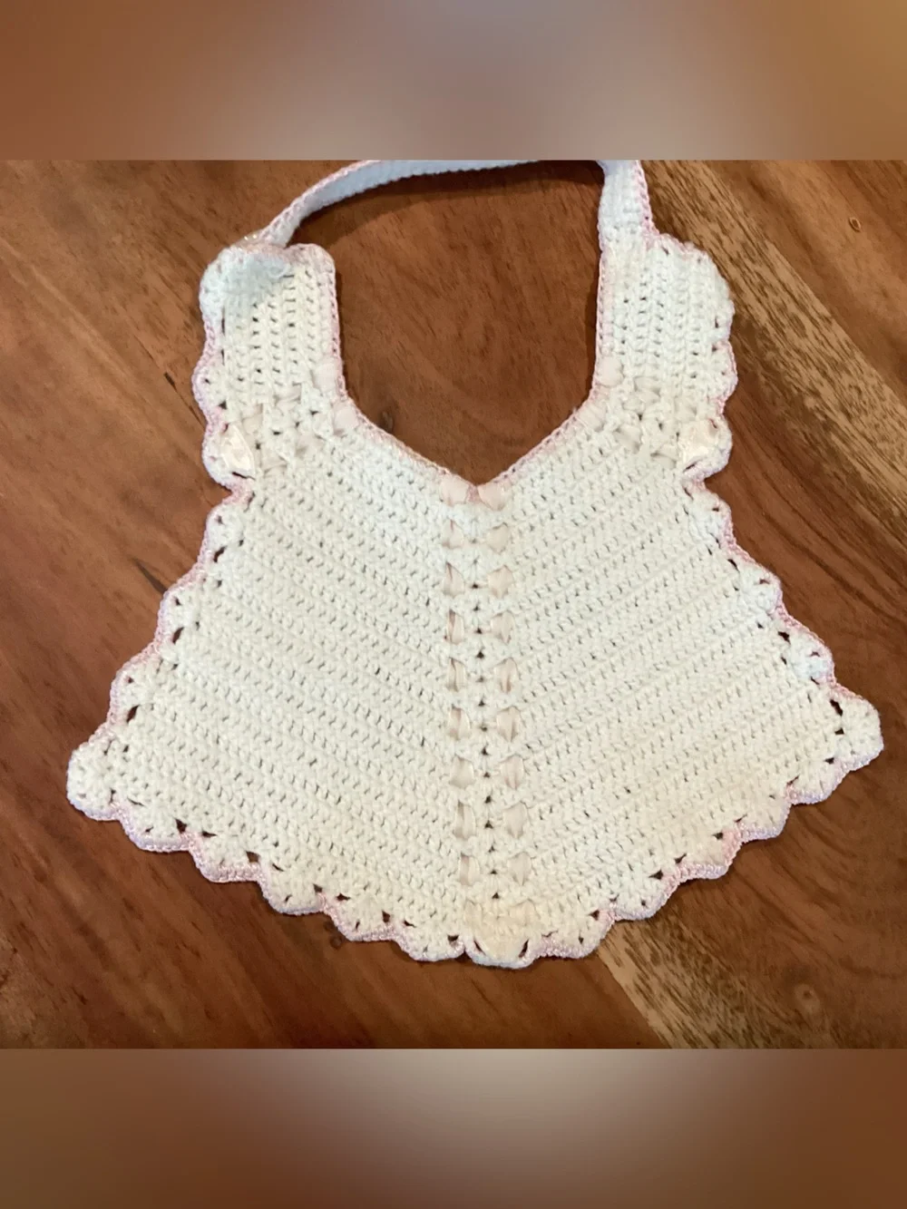 Vintage hand-made crocheted baby bib with pink scalloped lace look trim. 1950s